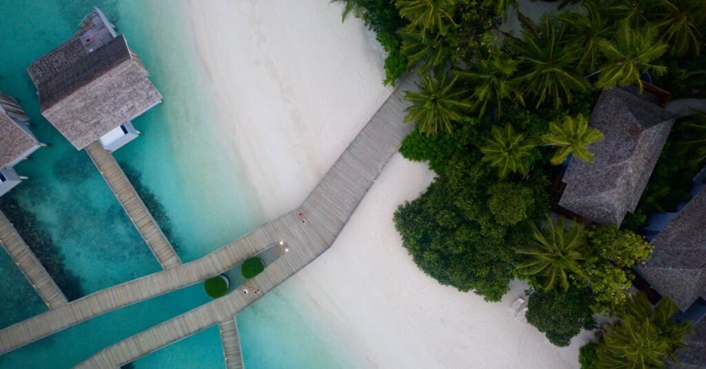 A stunning aerial view of a tropical beach resort with turquoise waters and lush greenery.